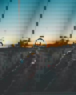 Groene jaloezieën met horizontale strepen, die een vaag uitzicht op een buitenlands landschap bieden.