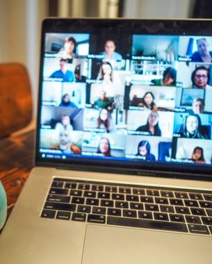 Pictured is a laptop screen showing an online meeting with many in attendance.